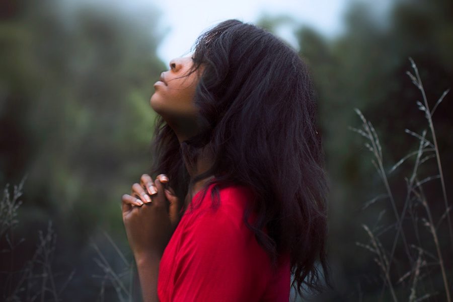 Woman standing amongst trees praying illustrating transforming your prayer life