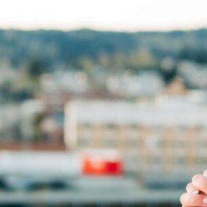 Woman praying with a city in the background, ready to change the world