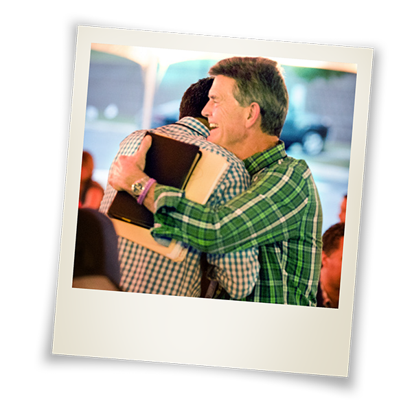 chip hugging international pastor with Bible