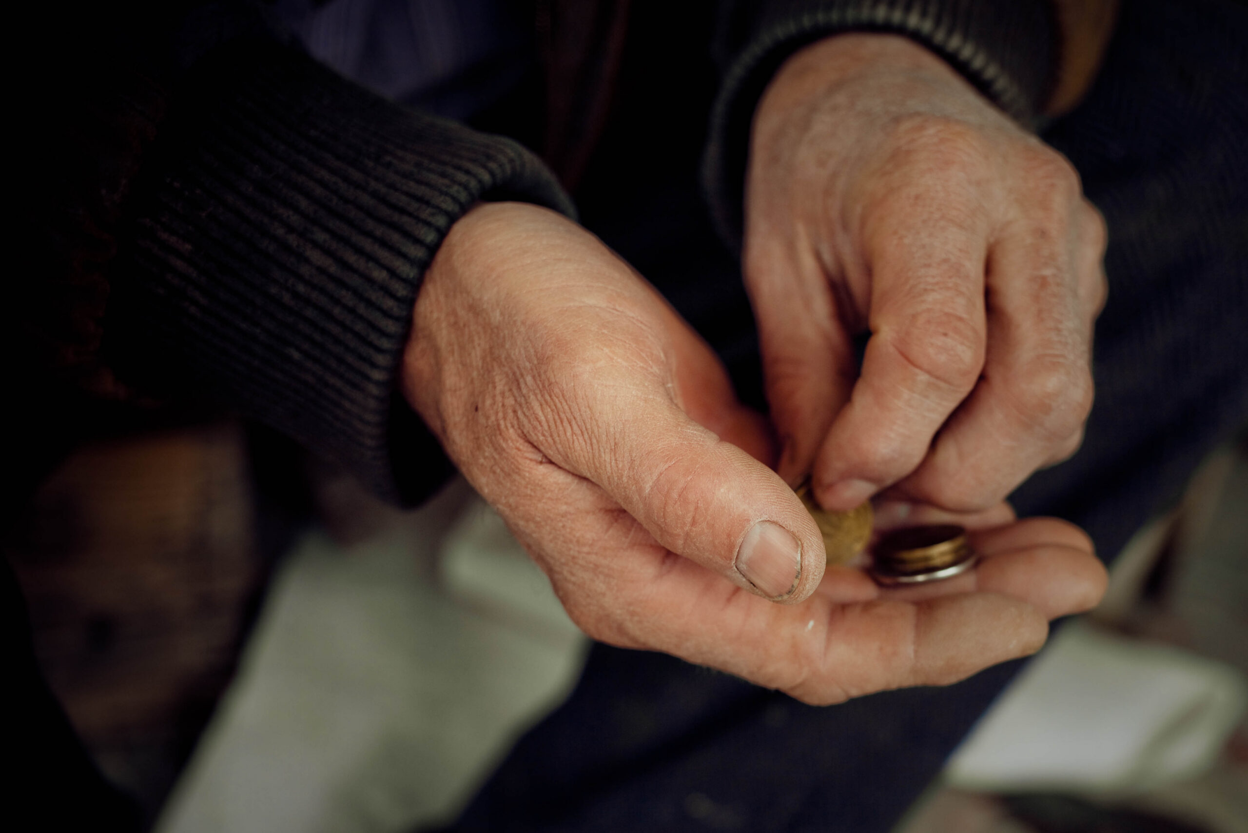 7 Bible Verses about Generosity-elderly man's hands carefully counting small coins