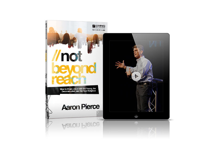 Not Beyond Reach" study guide book next to a tablet displaying video content.