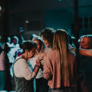 A small group of people gathered in prayer during a church service.